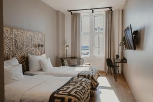 a hotel room with two beds and a television at Home Hotel Magasinet in Trelleborg