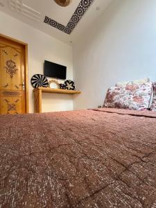 a bedroom with a large bed and a television at Garden view double room in Agadir
