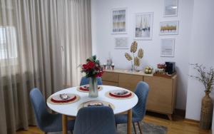 Un comedor con una mesa blanca y sillas azules en BeoCity 011, en Novi Beograd