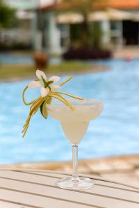 a martini glass with a white flower on a table at Baía Branca Beach Resort in Tamandaré