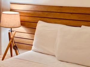 a bed with a white pillow next to a lamp at bamboo bed and breakfast in San Pedro Sula +11 photos