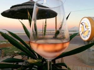 un verre de vin avec vue sur la plage dans l'établissement Studio plein sud le ciel le soleil et la mer, à Palavas-les-Flots