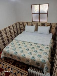Maison authentique au cœur des oasis في غرداية: سرير عليه وسادتين وبطانية