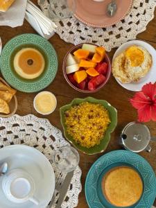 a table with plates of food and bowls of fruit at Vilare Pousada in Morro de São Paulo +52 photos