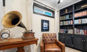 a room with a chair and a clock and book shelves at Luxurious 1875 centrally located Canton Akron home, large primary BR & sunset view in Uniontown