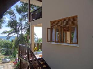 a house with a balcony with a view of the ocean at Fler Payanke Apartment in Anse Royale