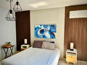 une chambre avec un lit et un tableau au mur dans l'établissement Departamento Olas, à Tuxtla Gutiérrez