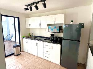 une cuisine avec un réfrigérateur en acier inoxydable et des armoires blanches dans l'établissement Departamento Olas, à Tuxtla Gutiérrez 8 autres photos