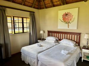 a bedroom with two beds with white sheets at Windmill Farm in Bergville