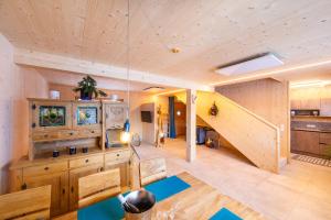 a large room with a wooden ceiling and a staircase at Ferienhaus Blauer Vogel - kostenfreie Saunanutzung in Prägraten