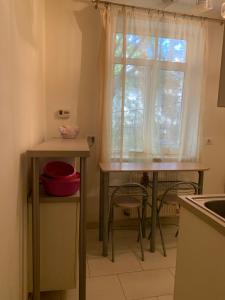 una cucina con finestra, tavolo e sedie di Cazare a Craiova Altre 4 foto