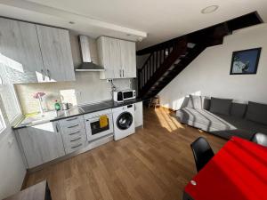 a kitchen and living room with a couch and a microwave at Cozy Apartment Madrid in Madrid
