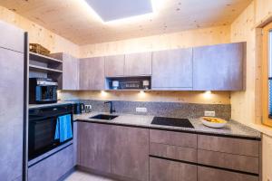 a kitchen with a sink and a stove at Ferienhaus Blauer Vogel - kostenfreie Saunanutzung in Prägraten