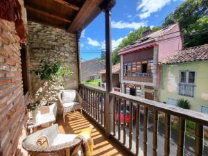 a balcony of a house with wicker chairs at El Juacu in Llanes