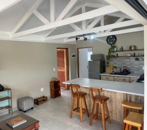 a kitchen with a counter and some wooden stools at Sysie Cottage in Sedgefield