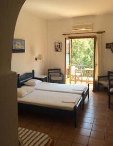 a bedroom with two beds and a balcony at Mealos Apartments in Skiros