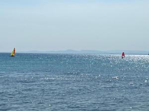 zwei Segelboote auf dem Wasser eines großen Gewässers in der Unterkunft Appartement coquet à Hammamet in Hammamet