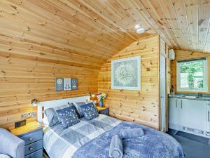 ein Schlafzimmer mit einem Bett in einem Holzzimmer in der Unterkunft 1 Bed in Church Stretton 90929 in All Stretton