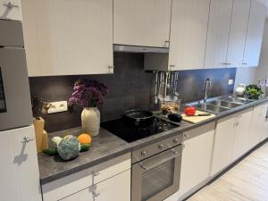 a kitchen with white cabinets and fruits and vegetables on the counter at De Kruishoeve in De Haan