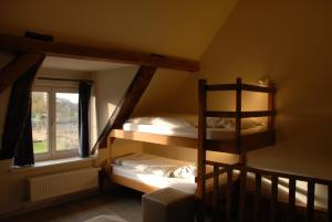 two bunk beds in a room with a window at De Kruishoeve in De Haan