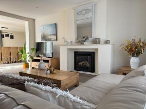 a living room with a couch and a fireplace at De Kruishoeve in De Haan