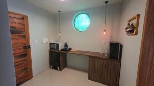 a room with a desk with a microwave and a window at Suite La Bela Vista in Angra dos Reis