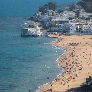 Ein Strand mit einem Haufen Leute im Wasser. in der Unterkunft Design, space and light in La Marsa in Dar Tahar Zaouch