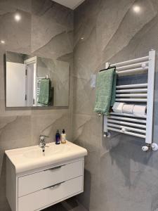 ein Badezimmer mit Waschbecken, Spiegel und Handtüchern in der Unterkunft Design, space and light in La Marsa in Dar Tahar Zaouch