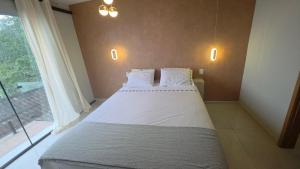 un grande letto in una stanza con una grande finestra di Suite La Bela Vista ad Angra dos Reis