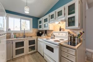 a kitchen with white appliances and blue walls at Casablanca - 3 BR Family & Game Haven in Calgary