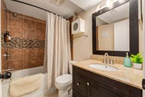 a bathroom with a sink and a toilet and a mirror at Casablanca - 3 BR Family & Game Haven in Calgary