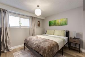 a bedroom with a bed and a window at Casablanca - 3 BR Family & Game Haven in Calgary +26 photos