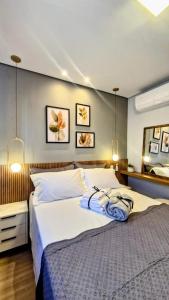 a bedroom with a large white bed and a mirror at Apartamento 1402 com 2 quartos, sala, cozinha completa, garagem, lazer e portaria 24h in Campinas