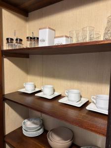uno scaffale con piatti, tazze e stoviglie sopra di Departamento Centro a General Pico