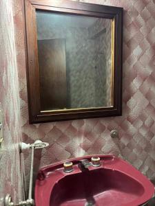 un bagno con un lavandino rosso e uno specchio di Departamento Centro a General Pico Altre 17 foto