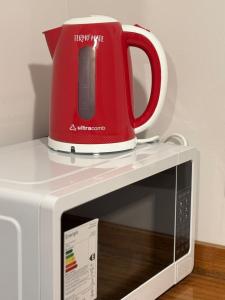 un apparecchio rosso seduto sopra un forno a microonde di Departamento Centro a General Pico