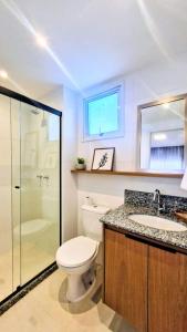 a bathroom with a toilet and a sink and a shower at Apartamento 1402 com 2 quartos, sala, cozinha completa, garagem, lazer e portaria 24h in Campinas
