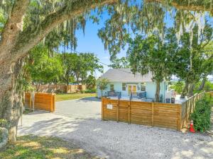 a house with a wooden fence and a tree at Waterfront Retreat Events Dock in St. Augustine