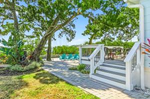 a porch with stairs and chairs under a tree at Waterfront Retreat Events Dock in St. Augustine
