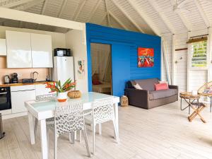 a kitchen and living room with a table and chairs at Au son des Grenouilles in Sainte-Rose