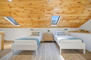 two beds in a room with a wooden ceiling at Waterfront Retreat Events Dock in St. Augustine +64 photos