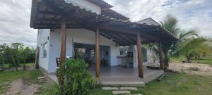 a small white house with a pergola at Casa Jardim in Marau