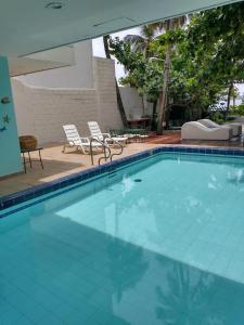 a large swimming pool with two chairs and a table at Casa - EL LAGUITO in Cartagena de Indias