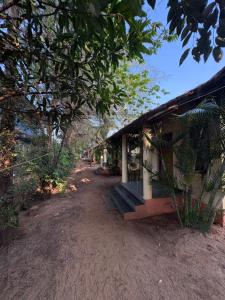 a building with a bench next to a dirt road at Barefoot and Beyond - Crafted with Kenchas in Gokarna