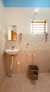 a bathroom with a sink and a toilet at Barefoot and Beyond - Crafted with Kenchas in Gokarna