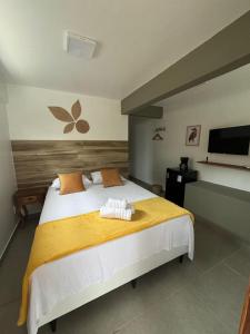 a bedroom with a large bed with towels on it at Casa Passarinho - Vale do Capão in Vale do Capao +28 photos