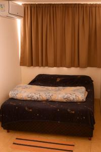 een bed in een kamer met een raam bij Cobertura Céu Aberto in Guaporé