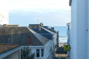 studio 2 personnes coeur de ville - proche plage في لي سابلِ دولونْ: إطلالة على مدينة في خلفية المحيط