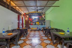 a dining room with tables and chairs and a chalkboard at Trivansh Resort Shivpuri Rishikesh in Shivpuri