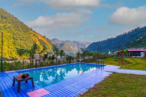 a swimming pool with a view of mountains at Trivansh Resort Shivpuri Rishikesh in Shivpuri